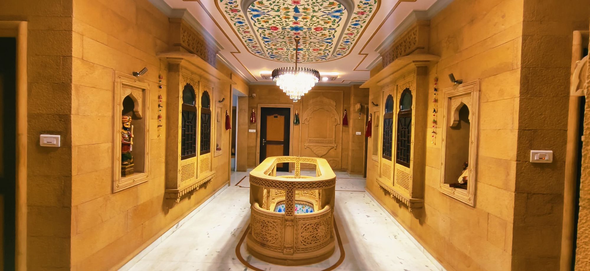 Sandstone atrium at Hotel Moonlight beneath a painted ceiling